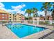 Community pool with surrounding patio at 5600 Devonbriar Way # 204, Orlando, FL 32822