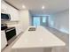 White kitchen with an island and stainless steel appliances at 849 Rivers Crossing St, Clermont, FL 34714