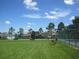 Community tennis courts with benches are surrounded by lush green lawns and mature trees at 11618 Grand Bay Blvd, Clermont, FL 34711