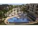 Bird's-eye view showcasing the freeform pool, numerous loungers, and lush landscaping of the community at 10601 Autumn Mist Ln # 302, Golden Oak, FL 32836