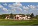 Impressive exterior view of a white luxury home with a red tile roof and arched entryway at 10601 Autumn Mist Ln # 302, Golden Oak, FL 32836