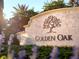 Golden Oak stone sign with decorative tree design and lush greenery at 10601 Autumn Mist Ln # 302, Golden Oak, FL 32836