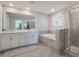 Elegant bathroom with double sinks, a soaking tub, and a walk-in shower at 1016 Downswing Pl, Davenport, FL 33896