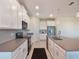 Modern kitchen with white cabinets, gray countertops, and stainless steel appliances at 1016 Downswing Pl, Davenport, FL 33896