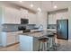 Modern kitchen with white cabinets, gray countertops, and stainless steel appliances at 1016 Downswing Pl, Davenport, FL 33896