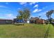 Expansive backyard featuring lush green grass, a covered outdoor seating area, and mature trees at 10416 Pocket Ln, Orlando, FL 32836