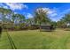 Large backyard featuring a covered outdoor seating area, and surrounded by lush greenery and mature trees at 10416 Pocket Ln, Orlando, FL 32836