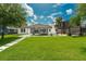 Expansive backyard with lush green lawn, modern pool, and elegant exterior of the home under a sunny sky at 10416 Pocket Ln, Orlando, FL 32836