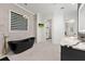 Bathroom featuring a black soaking tub, a window with blinds, and a double sink vanity at 10416 Pocket Ln, Orlando, FL 32836