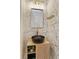Stylish powder room featuring patterned wallpaper, a unique vessel sink, and modern gold fixtures, creating a chic space at 10416 Pocket Ln, Orlando, FL 32836