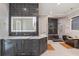Modern bathroom featuring a black tiled accent wall, soaking tub, and a vanity with a marble countertop and gold hardware at 10416 Pocket Ln, Orlando, FL 32836
