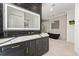 Modern bathroom with double sink vanity, stylish black accent tiles, a soaking tub, and glass enclosed shower at 10416 Pocket Ln, Orlando, FL 32836