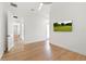 Bright bedroom featuring light hardwood flooring, modern ceiling fan, and a wall-mounted television at 10416 Pocket Ln, Orlando, FL 32836