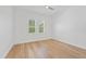 Bright bedroom featuring light hardwood flooring, modern ceiling fan, and two windows at 10416 Pocket Ln, Orlando, FL 32836