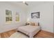 Inviting bedroom features natural light, a view of the outdoors, a comfortable bed, and light hardwood flooring at 10416 Pocket Ln, Orlando, FL 32836