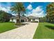 Gorgeous home boasts a sprawling front lawn, a paver driveway, and professional landscaping at 10416 Pocket Ln, Orlando, FL 32836