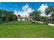 Wide front lawn with home, featuring a paver driveway, black fencing and green spaces at 10416 Pocket Ln, Orlando, FL 32836