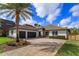 Beautiful home with an elegant driveway, a three-car garage, stone accents, and lush landscaping at 10416 Pocket Ln, Orlando, FL 32836