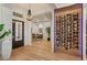 Elegant foyer with hardwood floors, a wine rack, a modern chandelier, and a view of the office at 10416 Pocket Ln, Orlando, FL 32836
