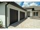 A home featuring a spacious, attached three-car garage with stylish carriage doors and a brick driveway at 10416 Pocket Ln, Orlando, FL 32836