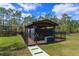 Backyard gazebo surrounded by a black metal fence, a lush lawn and mature trees at 10416 Pocket Ln, Orlando, FL 32836