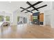 An expansive living room with a fireplace, tray ceiling and access to a dining area and outdoor living space at 10416 Pocket Ln, Orlando, FL 32836