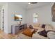 Cozy living room with a comfortable sectional sofa, leather ottoman, and a TV mounted above a stylish media console at 10416 Pocket Ln, Orlando, FL 32836