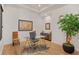 Bright office with hardwood floors, a glass desk, and a decorative tree at 10416 Pocket Ln, Orlando, FL 32836