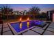 Backyard pool with an integrated spa, fire bowls, and lush landscaping at sunset at 10416 Pocket Ln, Orlando, FL 32836