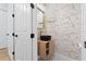 Stylish powder room with modern sink, wood-look vanity and decorative wallpaper at 10416 Pocket Ln, Orlando, FL 32836
