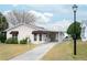 Charming single-story home includes a covered carport and a well-maintained front yard at 1207 Palmetto Dr, Lady Lake, FL 32159
