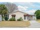 Inviting single-story home features a covered carport, landscaped yard, and awnings for windows at 1207 Palmetto Dr, Lady Lake, FL 32159