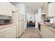 Full kitchen view, white cabinets, pink countertops, and stainless steel appliances at 1207 Palmetto Dr, Lady Lake, FL 32159
