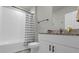 Clean bathroom with shower/tub combo, granite vanity, and white cabinets at 1231 Citrus Landings Blvd, Davenport, FL 33837