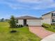 Single-story home with brick paver driveway and landscaped lawn at 1231 Citrus Landings Blvd, Davenport, FL 33837