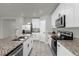 Modern kitchen with white cabinets, granite counters, and stainless steel appliances at 1231 Citrus Landings Blvd, Davenport, FL 33837