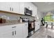Modern kitchen with white cabinets, granite counters, and stainless steel appliances at 1231 Citrus Landings Blvd, Davenport, FL 33837