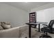 Home office with a standing desk, comfortable couch, and built-in bookcase at 1231 Citrus Landings Blvd, Davenport, FL 33837