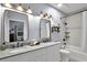 Bright bathroom featuring double sinks, granite countertop, modern fixtures and updated tile and lighting at 1730 Connecticut Ave, St Cloud, FL 34769
