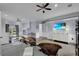 Bright bedroom features ceiling fan, private balcony access, and a beach scene playing on television at 1730 Connecticut Ave, St Cloud, FL 34769