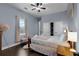 Charming bedroom with dark wood floors, light blue walls, and a comfortable bed with soft linens at 1730 Connecticut Ave, St Cloud, FL 34769
