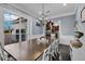 Bright dining room boasts large windows, a stylish chandelier, and a long wooden table at 1730 Connecticut Ave, St Cloud, FL 34769