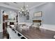 Elegant dining room features a long wooden table, stylish chandelier, and view to the kitchen at 1730 Connecticut Ave, St Cloud, FL 34769