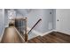 Hallway with wood floors, a wood and wrought iron railing staircase, and a white door at 1730 Connecticut Ave, St Cloud, FL 34769