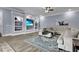 Spacious living room featuring a large sectional, built-in shelving, and modern ceiling fan at 1730 Connecticut Ave, St Cloud, FL 34769