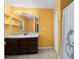 Bathroom with dark wood cabinets, double sinks, and a shower/tub combo at 290 Clydesdale Cir, Sanford, FL 32773