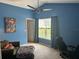 Bright bedroom featuring a modern ceiling fan, a large window, and blue accent wall at 290 Clydesdale Cir, Sanford, FL 32773