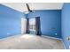 Bright bedroom with blue walls, ceiling fan, and window with curtains at 290 Clydesdale Cir, Sanford, FL 32773