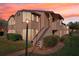 Exterior of a two-story building with stairway, showing well-maintained landscaping and cozy curb appeal at dusk at 2935 Antique Oaks Cir # 64, Winter Park, FL 32792