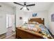 Bright main bedroom boasts wood floors, a ceiling fan and a decorative, woven bed frame with a colorful comforter at 2935 Antique Oaks Cir # 64, Winter Park, FL 32792